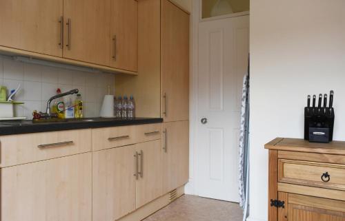 a kitchen with wooden cabinets and a counter top at Dale Street Apartments Suite in Leamington Spa