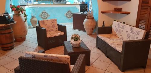a group of chairs and tables in a room at Hotel Rodà in Panarea