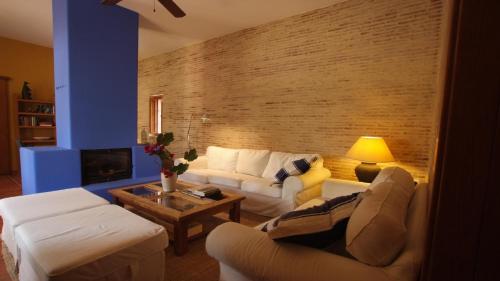 ニハルにあるCasa El Arenalの白い家具とレンガの壁が備わるリビングルーム