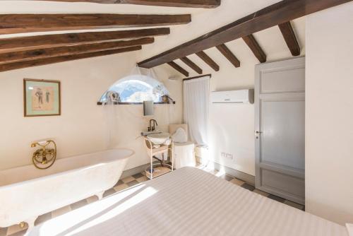 a white bathroom with a tub and a sink at Valuable rustic Tuscan swimming pool, breathtaking view of Camaiore in Camaiore