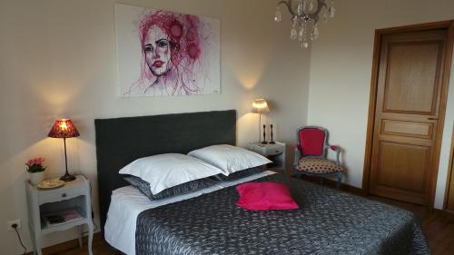 a bedroom with a bed with a pink pillow on it at Le balcon du fêtre (Maria & Jean Louis Chapuy) in Chiroubles