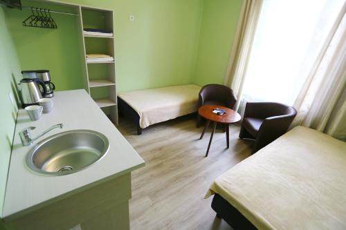 a bathroom with a sink and a bed and a table at Hostel Sport in Haapsalu