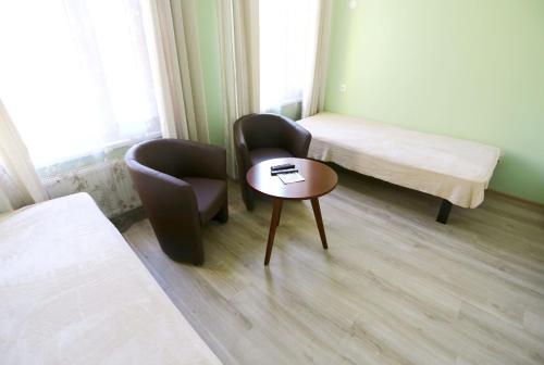 a room with two chairs and a table and a bed at Hostel Sport in Haapsalu