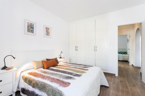 a white bedroom with a bed and white cabinets at La Casita del Albir in Albir