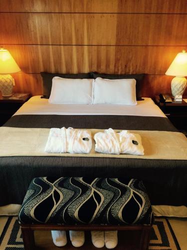two beds in a hotel room with towels on them at Convair Hotel in Ciudad del Este