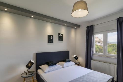 een slaapkamer met een bed met twee lampen en een raam bij Villa Apartment AA 2 in Trogir