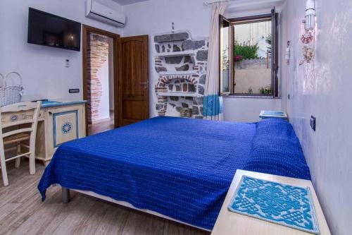 a bedroom with a blue bed in a room at Il Leccio in Tortolì