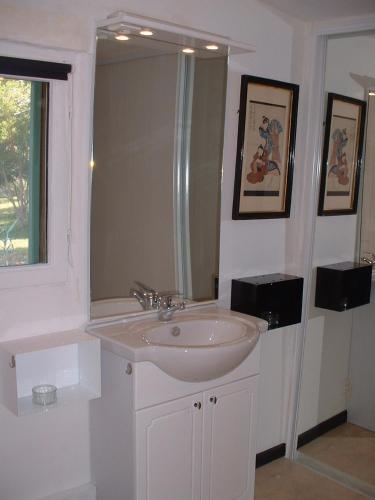 une salle de bain blanche avec un lavabo et un miroir dans l'établissement Chambre d'Hotes C de C, à Sauliac-sur-Célé