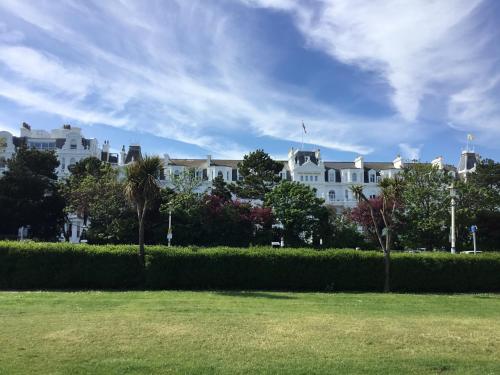 a large white building with trees in front of it at Silverdale Holiday Apartments in Eastbourne