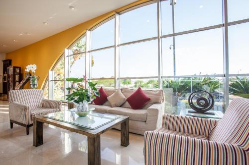 a living room with a couch and chairs and a table at Grupotel Playa de Palma Suites & Spa in Playa de Palma