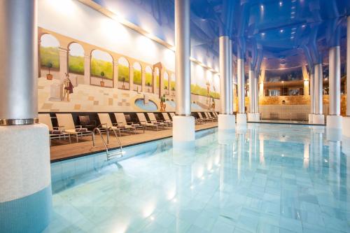 a swimming pool in a building with tables and chairs at Grupotel Playa de Palma Suites & Spa in Playa de Palma