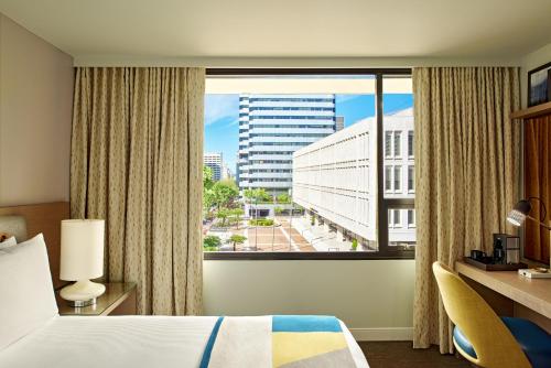 a hotel room with a bed and a large window at The Hotel Zags Portland in Portland