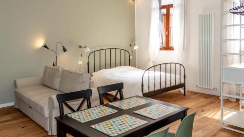 a living room with a bed and a table and a couch at BRE Apartments - Fresche Frasche in Vicenza