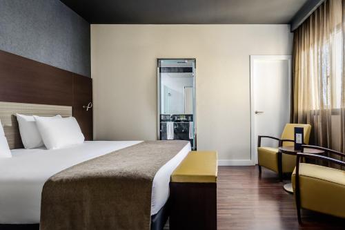 a hotel room with a large bed and a desk at Eurostars Asta Regia Jerez in Jerez de la Frontera