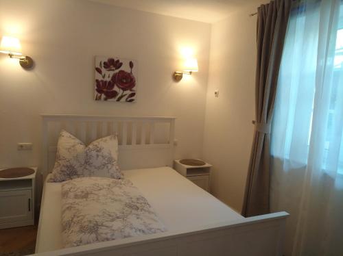 Dormitorio pequeño con cama blanca y almohadas en Gästezimmer Brühl, en Markt Sankt Florian