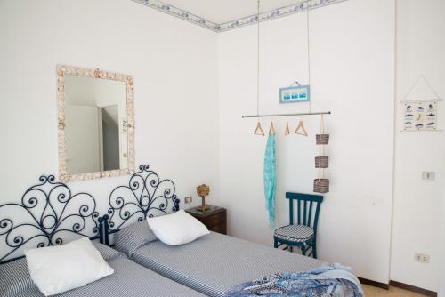 een slaapkamer met een bed, een spiegel en een stoel bij Acquamarina in Alba Adriatica
