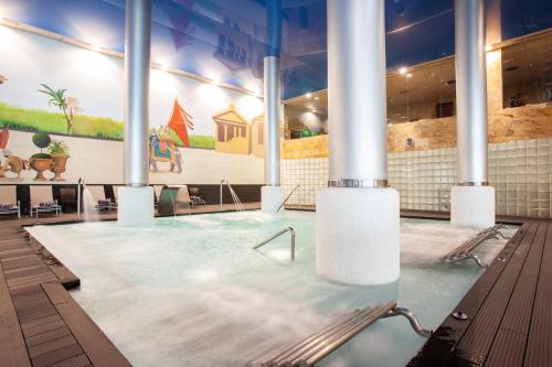 a swimming pool in a large room with columns at Grupotel Playa de Palma Suites & Spa in Playa de Palma