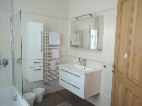 Baño blanco con lavabo y espejo en Gästezimmer Brühl, en Markt Sankt Florian