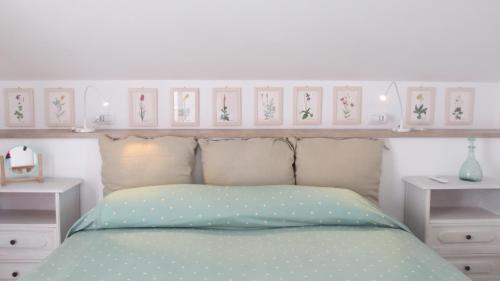 a bedroom with a bed and a shelf with pictures on it at B&B Casa Soresina in Offagna