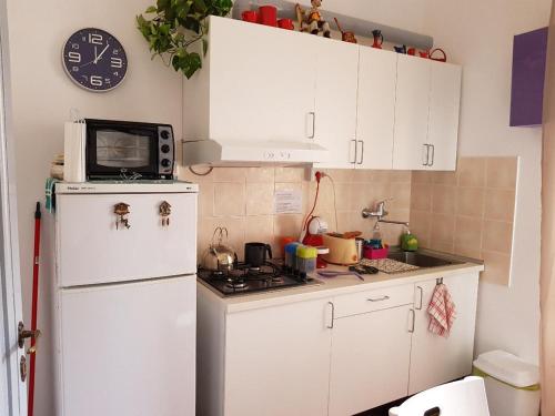eine Küche mit einem weißen Kühlschrank und einer Mikrowelle in der Unterkunft Il Cucù B&B in Frascati
