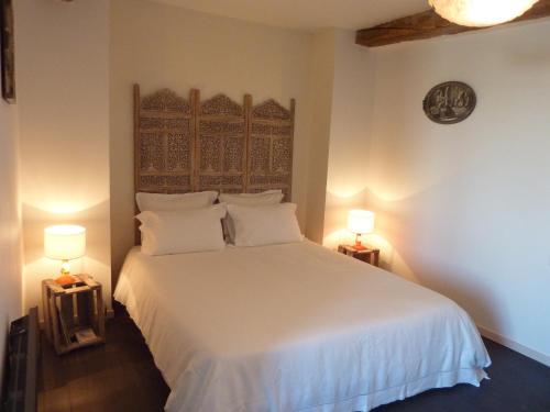 a bedroom with a white bed with two lamps at Harrieta in Masparraute