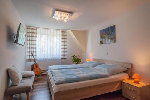 a bedroom with a bed and a guitar in it at Ferienwohnungen Ludwigsthal in Ludwigsthal