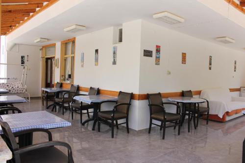 a dining room with tables and chairs and a bed at Ozge Pansiyon in Didim