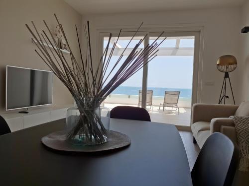 a living room with a table with a vase on it at Fiume Luxury Apartments near the SEA in Monopoli
