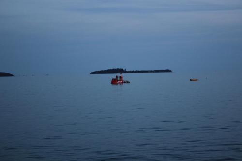 a red boat in the middle of the water at Apartman L&P in Fažana