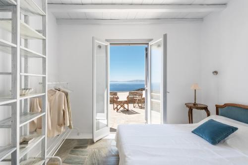 a bedroom with a bed and a view of the ocean at Evita's Villas-Tinos in Tinos