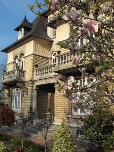 a large house with a balcony on top of it at Le Castel Guesthouse in Bayeux