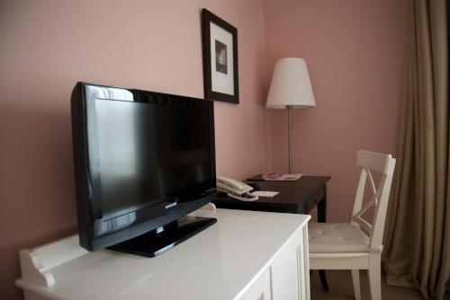 a flat screen tv sitting on top of a white table at Hotel Vanilla in Timişoara