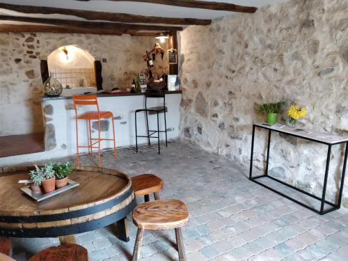 Cette chambre comprend une table, des chaises et un comptoir. dans l'établissement Le balcon du fêtre (Maria & Jean Louis Chapuy), à Chiroubles