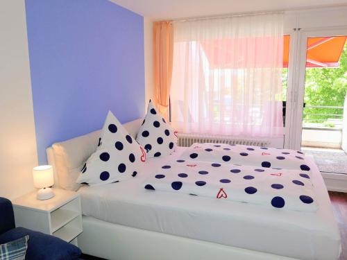 a bedroom with a white bed with pillows and a window at Ferienapartement Boot in Meersburg