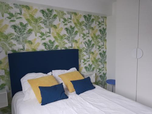 サン・ジャン・ド・リュズにあるAppartement St Jean de Luzのベッドルーム1室(黄色と青の枕付きのベッド1台付)