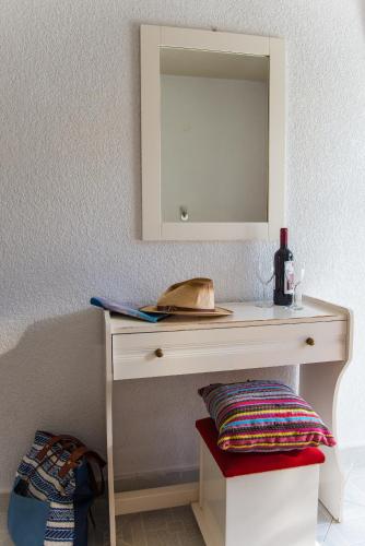 a dressing table with a mirror and a bottle of wine at Vassilis Studios in Poros