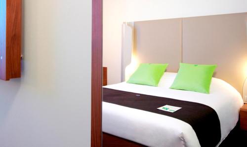 a bedroom with a bed with green pillows at Campanile Wroclaw Centrum in Wrocław
