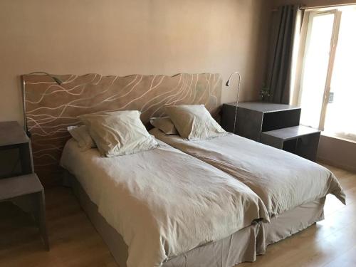 ein Bett mit zwei Kissen darauf in einem Schlafzimmer in der Unterkunft Aux Delices de l'Abbaye in Orbais