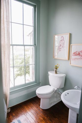 un bagno con un water, un lavandino e una finestra di Carr Mansion a Galveston