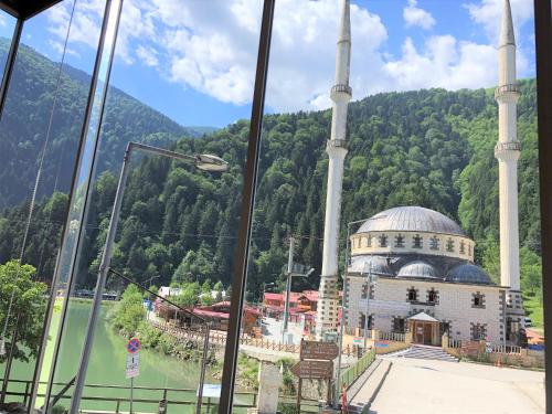 a building with a mosque in front of a mountain at Onal Motel in Uzungöl