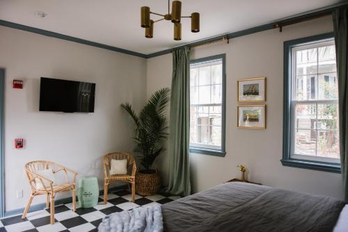 a bedroom with a bed and a tv and windows at Carr Mansion in Galveston