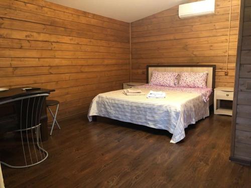 a bedroom with a bed with wooden walls and a piano at Гостевой дом "OSCAR" in Gagra