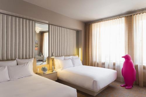 a hotel room with two beds and a large window at 21c Museum Hotel Durham in Durham