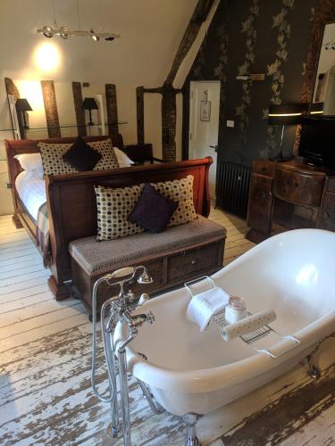 a bath tub in a room with a bed at The Wellington in Welwyn