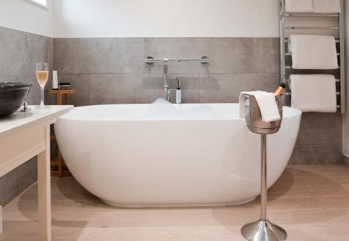 a white bath tub in a bathroom with a sink at The Montagu Arms in Beaulieu