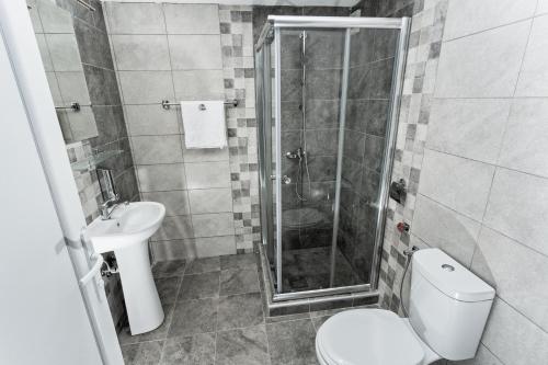 a bathroom with a shower and a toilet and a sink at Skopje Downtown Hostel in Skopje