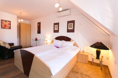a bedroom with a large white bed in a attic at Guest Rooms Tivona in Pazardzhik