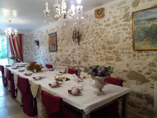a dining room with a long table with red chairs at le relais d'elle in Niozelles