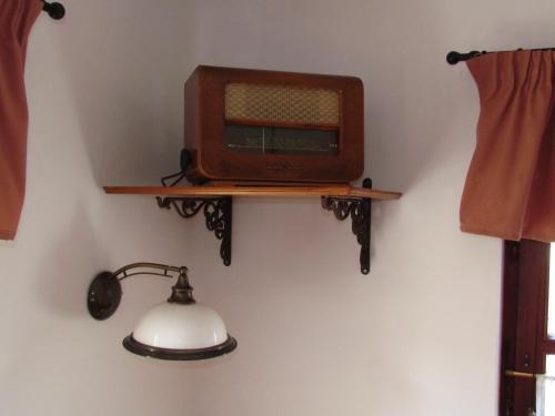 a tv on a wall with a lamp on a wall at Torkolat Panzió in Tokaj