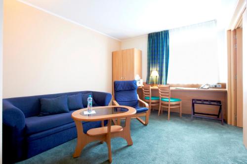 a living room with a couch and a table and chairs at Campanile Poznan in Poznań